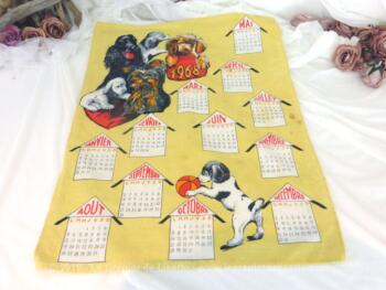 Ancien torchon calendrier 1968 de 60 x 46 cm sur fond jaune paille avec en décoration des chiens qui s'amusent.