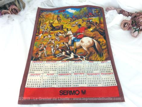 Ancien torchon calendrier 1973 de 59 x 43 cm sur fond marron avec en décoration une partie de chasse à courre.