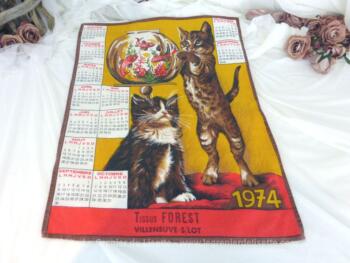 Ancien torchon calendrier 1974 de 58 x 45 cm sur fond rouge avec en décoration deux chats qui jouent avec un aquarium.