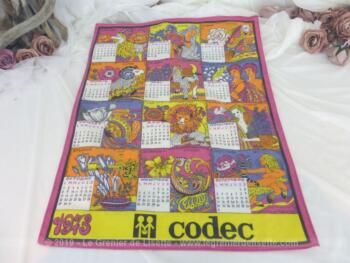 Ancien torchon calendrier 1973 de 60 x 46 cm sur fond fuchsia avec en décoration les douze signes astrologiques.