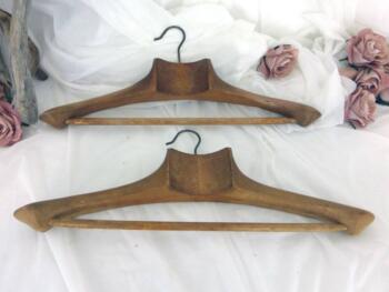 Avec une superbe patine, voici un duo de cintres anciens en bois avec large col et porte pantalon.