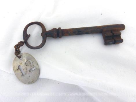 Accouchée à une très vieille clé recouverte de sa patine authentique, il y a une ancienne plaque en zinc avec le chiffre 12 poinçonné en creux