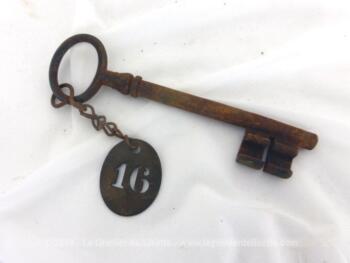 Accrochée à une très vieille clé recouverte de sa patine authentique, il y a une ancienne plaque en zinc avec le chiffre 16 poinçonné en creux,