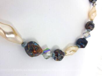 Voici ancien collier réalisé en perles de verre nacrées et en pierres polies. Montées sur un fil épais, toutes les perles sont calées par des noeuds.