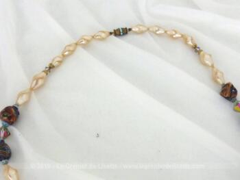 Voici ancien collier réalisé en perles de verre nacrées et en pierres polies. Montées sur un fil épais, toutes les perles sont calées par des noeuds.