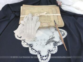 Composition shabby autour de la musique, avec d'anciennes partitions cartonnées, un mouchoir de mariée, un pince nez, une paire de gants au crochet et un porte plume. Décoration unique.