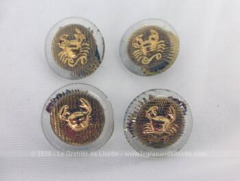Quatre boutons en verre décorés d'un crabe en métal doré en relief sur le dessus et une rondelle en laiton dessous .