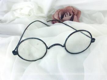 Ancienne paire de lunettes rondes en métal patinée et oxydée par le temps pour une décoration remplie d'authenticité.
