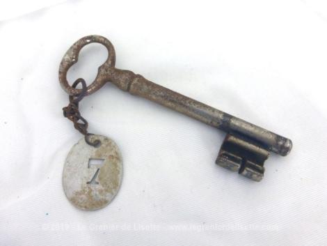 Accouchée à une très vieille clé recouverte de sa patine authentique, il y a une ancienne plaque en zinc avec le chiffre 7 poinçonné en creux