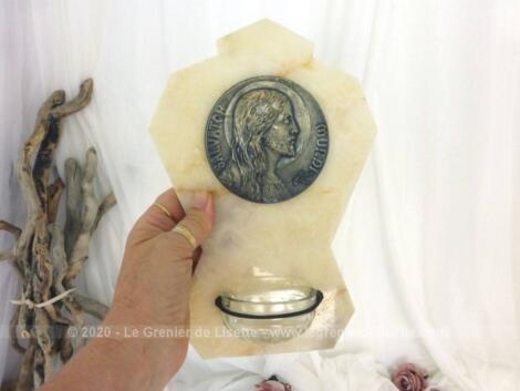 Ancien bénitier en marbre clair avec pour décoration un écusson signé en laiton représentant le visage du Christ entouré du texte "Salvotor Mundi" .