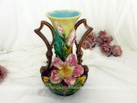 Ancien vase en barbotine numéroté et signé, et décoré de 3 iris roses en relief , de couleur ocre et intérieur bleu pastel avec des anses marrons originales.