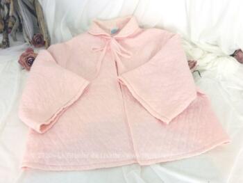 Ancienne liseuse de couleur rose en nylon avec manches larges et rubans pour fermer.