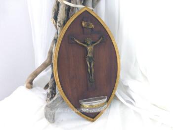 Voici un bénitier original en bois de forme ovoïde avec un crucifix en bois avec le Christ en laiton, réceptacle en verre et tous les contours en laiton.