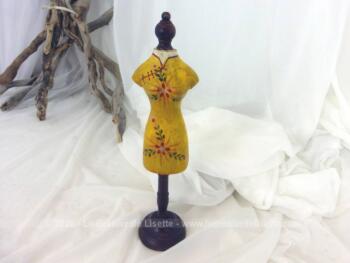 Petit mannequin en bois, sur pied façon piédestal, très décoratif avec un robe jaune à fleurs façon chinoise peinte sur le corps.