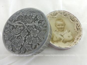 Poudrier en aluminium de la marque "Cheramy Paris" en deux parties, une avec un miroir et l'autre revisitée en porte photo avec la photo d'un bébé et décorée de dentelle. Pièce unique.