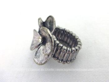 Montée sur métal couleur argent, voici une belle bague en forme de fleur aux pétales ouverts et dont l'anneau en perles métalliques est étirable. Idéal pour tous les doigts à partir de 2 cm de diamètre.