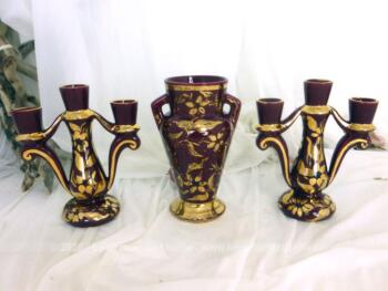 Totalement assorti et datant des années 50, voici un paire de chandeliers et un vase en céramique grenat et or, numérotés et signés 