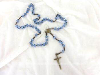 Voici un ancien chapelet aux perles de verre à facettes bleu ciel avec croix et médaille en métal argenté.