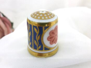 Dé à coudre en porcelaine estampillé "Royal English Fine Bone China" (porcelaine fine à l'os) décoré de belles dorures et de deux rosaces couleur saumon. Très élégant.