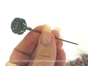 Ancienne petite épingle à chapeaux de 8 cm est composée d'une partie sphérique métallique ciselée par des volutes et arabesques pour la décorer comme un bijoux.