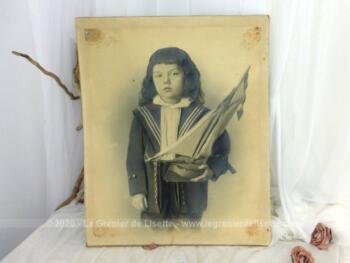 Voici une ancienne grande photo datant de la fin du XIX° représentant un garçonnet en tenue de marin portant dans ses bras un voilier modèle réduit. Photo libre de droit 61 x 51 cm.