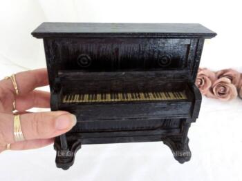Voici un ancien piano droit en bois pour maison de poupées fait main et daté de 1932 avec son couvercle qui se soulève pour laisser apparaitre un papier représentant le clavier.