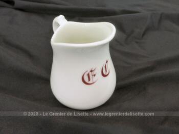 Voici un petit pot à lait en faïence blanche, numéroté et décoré en bordeaux de deux monogrammes, E et C ?