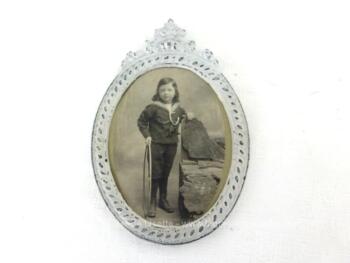 Voici un ancien petit cadre ovale en métal de 12 x 9 cm, patiné shabby avec la photo d'un garçonnet. Pièce unique.