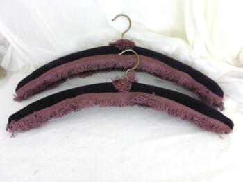 Voici un duo de cintres anciens identiques et décorés de velours violet et d'un galon frangé parme.