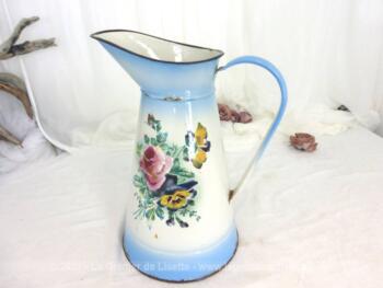 Ancien broc émaillé sur fond bleu avec décorations fleuries d'origine et sa patine authentique avec éclats et traces d'oxydation.