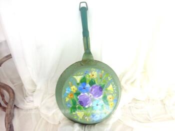 Ancienne poêle décorée à la main sur fond vert pastel avec des dessins uniques de fleurs colorées. Pour une décoration vintage.