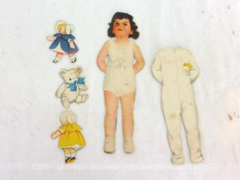 Voici une ancienne poupée à découper en papier avec ses habits et ses jouets.