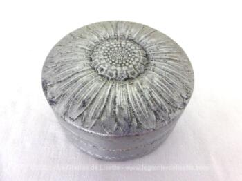 Voici un ancienne boite à savon en fer blanc ronde, avec de belles décorations en relief prenant la forme d'un tournesol.
