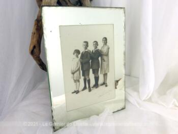 Sur 24 x 18 cm, voici un ancien cadre miroir des années 40 avec une vieille photo de 12 x 17 cm datant des années 20 avec tous les enfants d'une même famille.