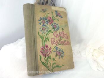 Ancien album des années 20/30 de 90 feuilles pour cartes postales anciennes de 38.5 x 22.5 x 5 cm avec sur la couverture cartonnée des dessins peints à la main de fleurs ainsi que des mots 