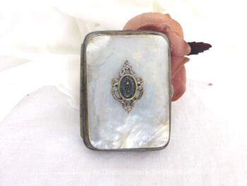 Petite aumônière nacre, façon porte monnaie, avec ses 4 compartiments et décorée d'une incrustation en forme d'écusson en métal argenté.