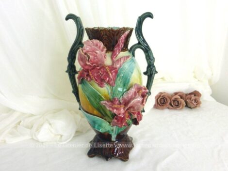 Voici un ancien vase en barbotine aux grandes fleurs d'iris rose en relief. Ses anses, son col et son socle en soulignent toute son harmonie.