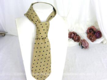Voici une ancienne cravate en soie sur fond beige et décorée de pois couleur marine. Pour homme ou femme !