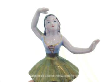 Adorable figurine en céramique d'une marquise danseuse à la jupe dorée sur 14.5 cm de haut sur piédestal rond.avec un bras au dessus de la tête.