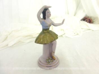 Adorable figurine en céramique d'une marquise danseuse à la jupe dorée sur 14.5 cm de haut sur piédestal rond.avec un bras au dessus de la tête.