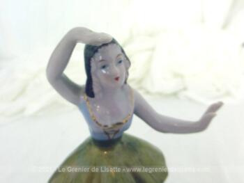 Adorable figurine en céramique d'une marquise danseuse à la jupe dorée sur 14.5 cm de haut sur piédestal rond.avec un bras au dessus de la tête.