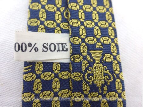 Voici une ancienne cravate en soie portant l'étiquette "FFR Coupe du Monde 1999" et "Création Projectif". Sur fond marine, coupes et ballon se mêlent pour former un motif. Vintage !
