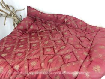 Voici un ancien édredon bien épais de 122 x 122 cm en tissus bordeaux satiné rembourré par de la laine cardée maintenues par des coutures piqués formant un quadrillage trés esthétique.