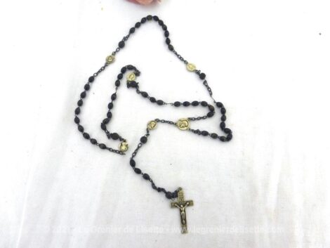 Voici un ancien chapelet aux perles de verre marron avec croix et nombreuses médailles en métal argenté.