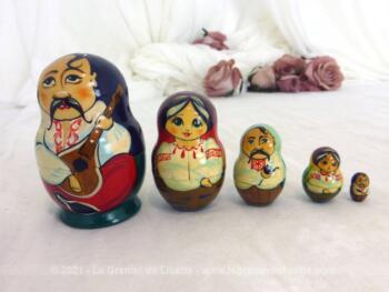 Jeu de 5 poupées matriochkas représentant une famille Tzigane avec la signature cyrillique de leur origine slave, dont la plus grande mesure 8 cm.