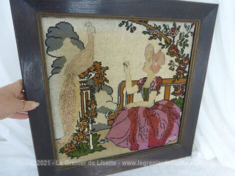 Voici un cadre en bois mettant un valeur un canevas d'une charmante jeune fille et un paon, mélangeant fils de coton et tissus pour un ensemble tendance shabby.