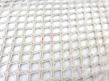 Voici un ancien dessus de cheminée ou de commode réalisé au crochet en fils de coton bistre et décoré de pompons en spirales.