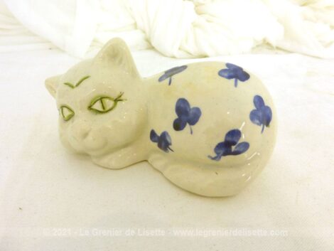 Voici une belle petite figurine représente un chat blanc aux grands yeux verts avec des feuilles bleues sur le corps et signé Vallauris.