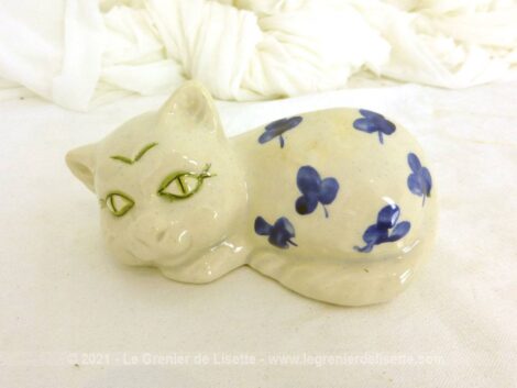 Voici une belle petite figurine représente un chat blanc aux grands yeux verts avec des feuilles bleues sur le corps et signé Vallauris.