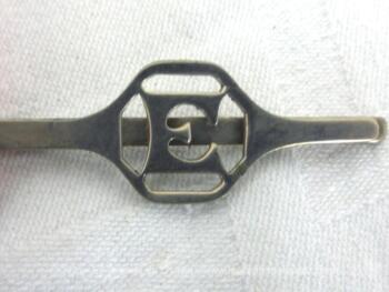 Voici une ancienne pince à cravate des années 60/70 avec en décoration le monogramme E. Alors pour cravate pour homme ou pour foulard pour femme ?
